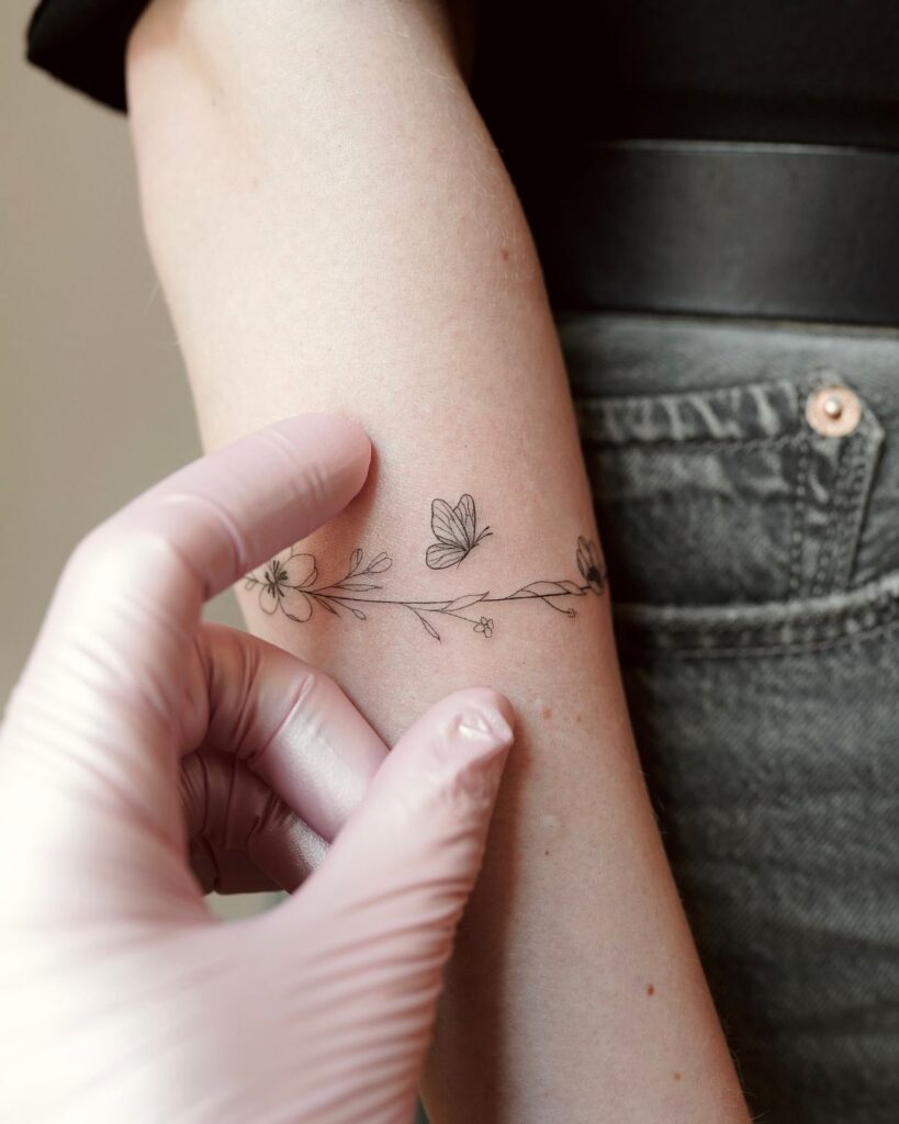 Feines Fineline Tattoo mit kleinen symbolischen Motiven